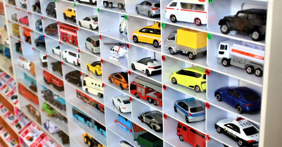 A large collection of organized toy cars. They are displayed in a cubby storage and labeled by numbers.