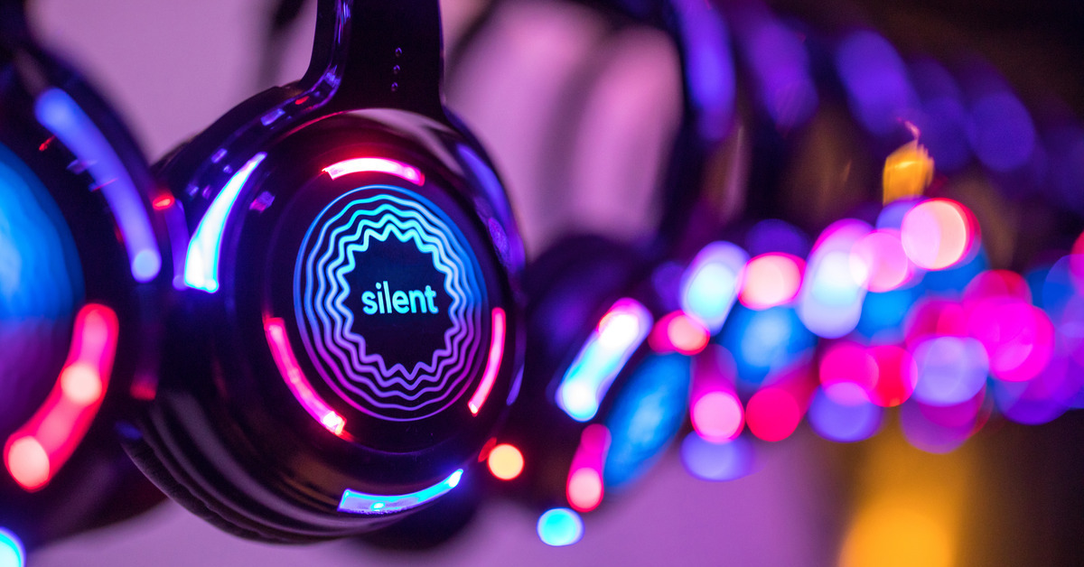 several pairs of headphones for a silent disco, illuminated by colorful LED lights