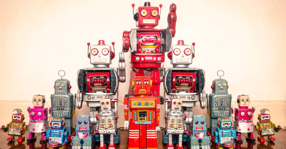 An array of toy robots of various shapes, sizes, colors, and designs, arranged in a pyramid shape by height.